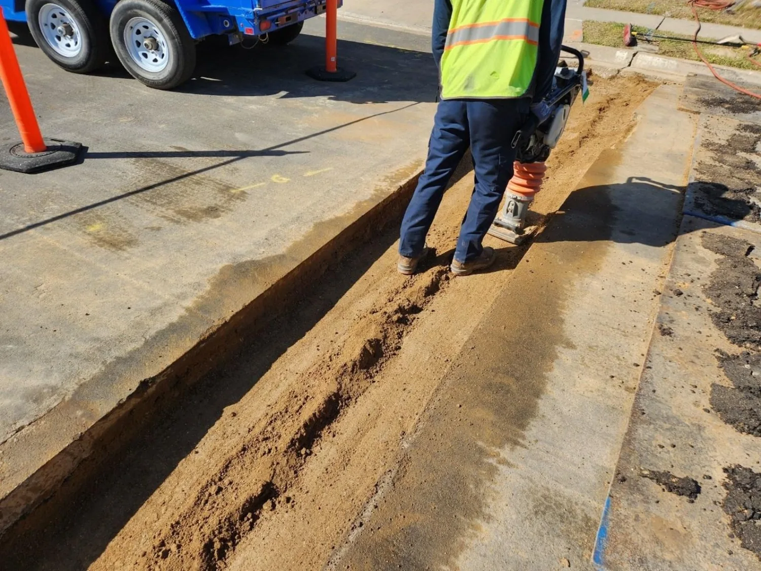 Backfill compaction underway in excavated utility trench