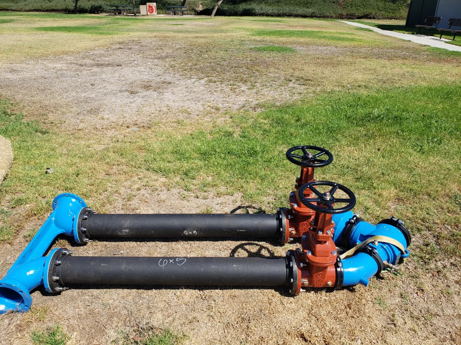 New backflow valve and piping assembly laid out before installation