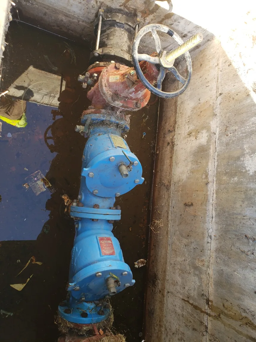 Original backflow assembly located in a water-filled underground concrete vault