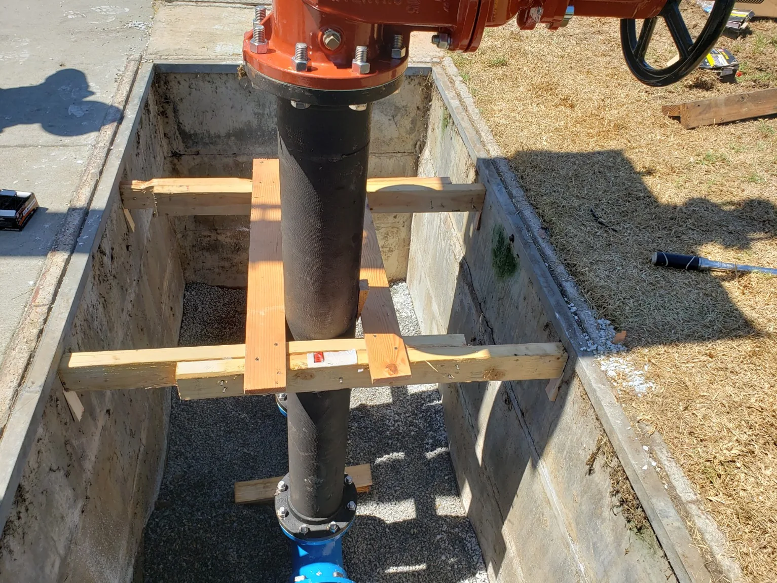 Backflow risers temporarily supported during installation in the vault