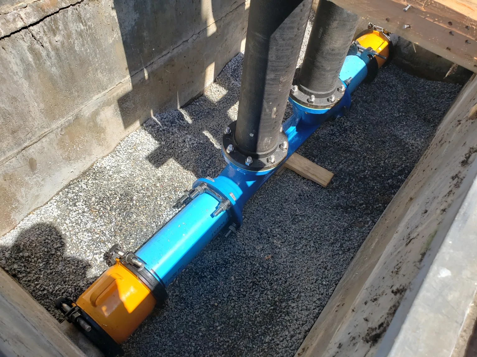 Reconnected underground water piping and gravel backfill in vault
