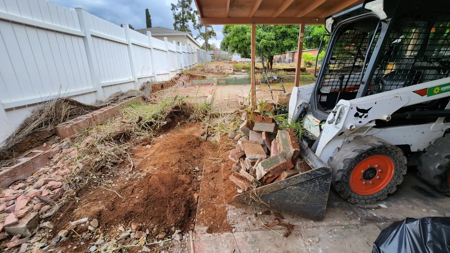 Skid steer removing demolished masonry and concrete debris