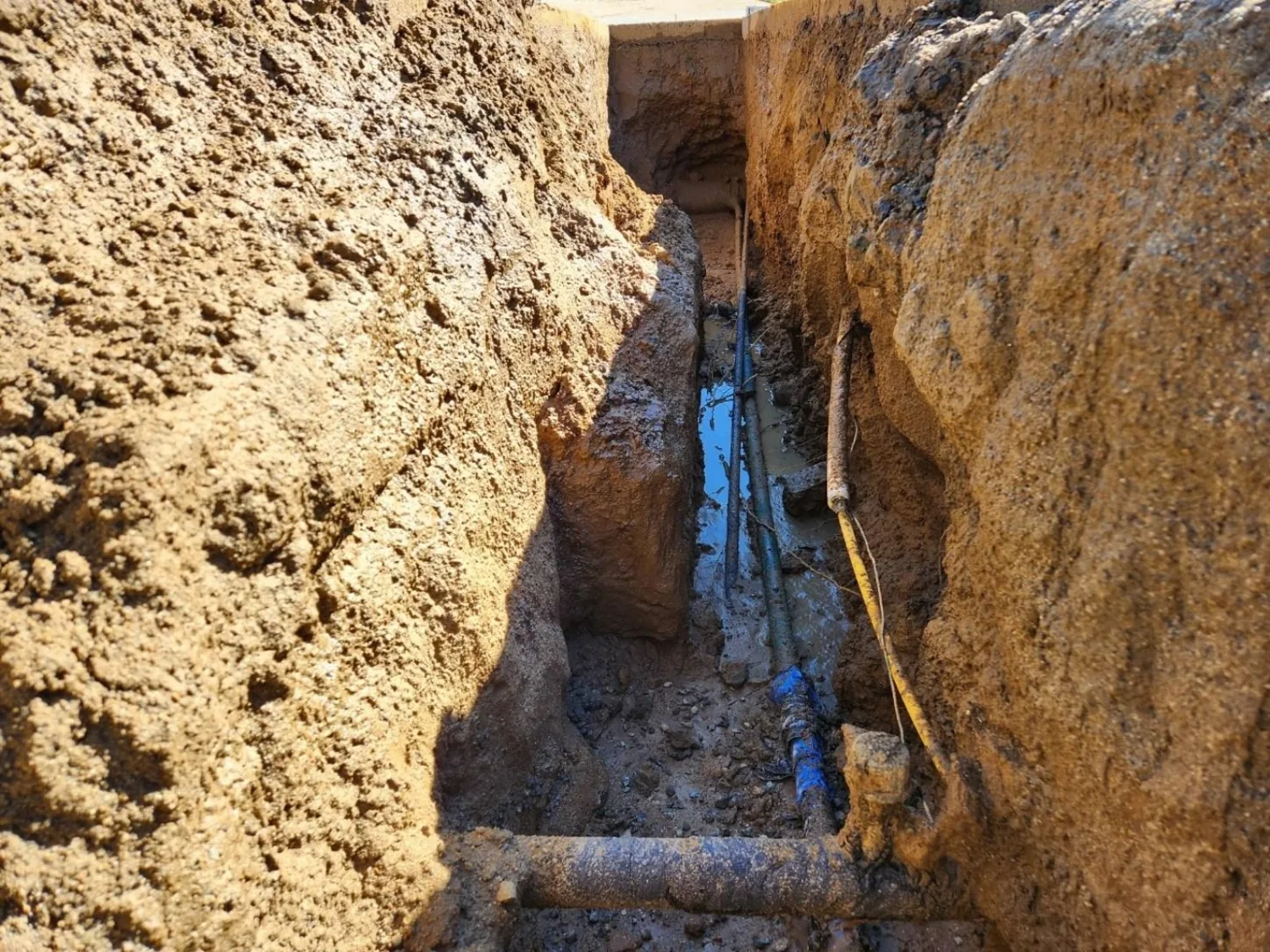 Exposed utility piping within excavated trench